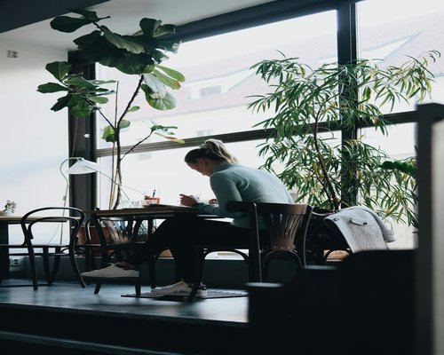 person taking a short break looking out the window from a coworking space
